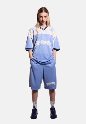 Light blue jersey and matching shorts made of a breathable fabric, featuring white accents and graphic logo. Worn with blue sneakers.