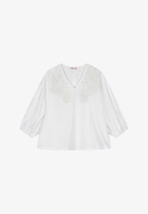 Witte katoenen blouse met een V-hals en driekwart pofmouwen. Voorzien van geborduurde bloemenpatronen over het borstgebied.