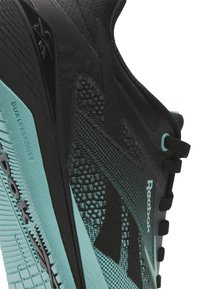 Sorte svart og teal treningssko med teksturert mesh-overdel, solid såle og Reebok-logo på siden, designet for ytelse.