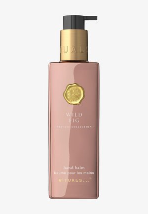 Rosa rektangulær flaske med håndbalm og gullpumpe. Etiketten har teksten «WILD FIG» og «RITUALS» i hvit og gull skrift.