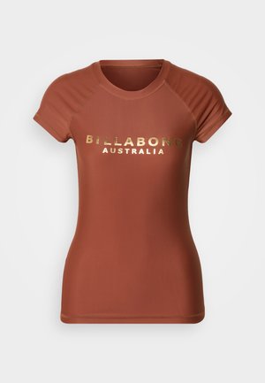 Rust-colored fitted short-sleeve shirt with "BILLABONG AUSTRALIA" printed in gold foil across the chest.