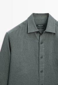 Chemise en lin gris foncé à manches longues avec un col classique et des boutons sur le devant, étiquetée Massimo Dutti, fabriquée en Chine.