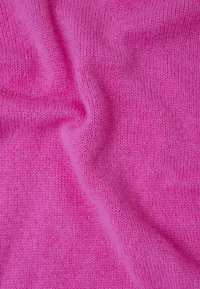 Zacht roze gebreide stof met een gladde textuur, met een uniform patroon en een lichte drape, die zijn buigzaamheid en levendige kleur toont.