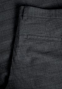Pantaloni grigio scuro con un delicato motivo a scacchi, dotati di passante per cintura e una singola tasca a filetto sul retro.