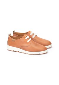 Zapatillas de cuero marrón con cordones blancos, paneles laterales texturizados y suela de goma blanca. Presenta un pequeño detalle de logo dorado.