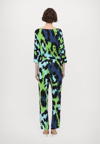 Bunter Overall mit abstraktem Muster in Blau, Grün und Schwarz. Er hat eine lockere Passform, lange Ärmel und eine taillierte Taille.