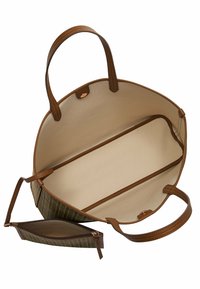 Sac fourre-tout rond avec un extérieur à motifs en vert olive et marron. L'intérieur présente une doublure beige, deux compartiments et une pochette zippée.