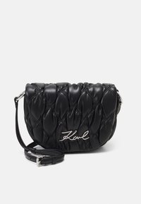 Black quilted leather bag featuring a rounded shape, silver hardware, adjustable strap, and a diagonal "Karl" logo detail on the front.