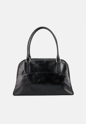 Schwarze Lederhandtasche mit zwei abgerundeten oberen Griffen und einer leicht gebogenen Fronttasche, dargestellt vor einem einfarbigen hellen Hintergrund.