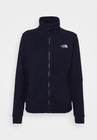 Veste en polaire bleu marine avec fermeture éclair, col montant et logo sur le haut à gauche. Texture douce et coupe régulière avec manches longues.