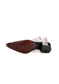 Bota de cowboy de cuero blanco con bordado rojo, punta afilada, tacón negro y un gráfico detallado en la suela. Presenta un cierre de cremallera.