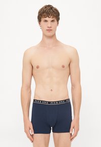 Navyblaue Boxershorts mit einem schwarzen elastischen Bund, der mit weißen "PIER ONE" Buchstaben versehen ist. Weiches Baumwollmaterial, enganliegendes Design und mittellange Beinlängen.