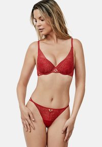 Rood kanten beha met een driehoekige vorm en verstelbare bandjes, met een decoratief metalen accent in het midden. Wordt geleverd met een bijpassende kanten string.