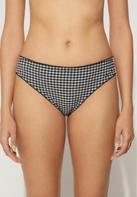 Bikini kalhotky v černobílé kostkované vzoru s hladkým textilním povrchem, vysokým vykrojením nohavic a elastickým pasem.