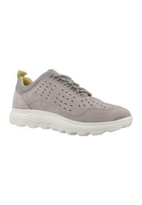 Zapatilla de ante gris claro con diseño perforado, lengüeta de malla gris texturizada, suela blanca acolchada y tira amarilla en el talón para facilitar su uso.