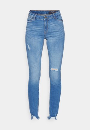 Jeans skinny azuis feitos de denim, com uma cintura alta, detalhes desgastados e bainhas desfiadas para um visual casual e moderno.