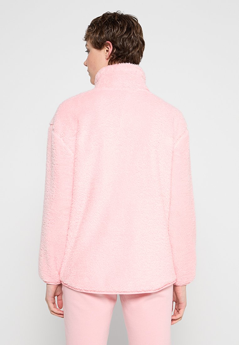 Rosa Fleece-Pullover mit hohem Kragen, langen Ärmeln und einer weichen, strukturierten Oberfläche. Verfügt über einen abgerundeten Saum und eine lässige Passform.