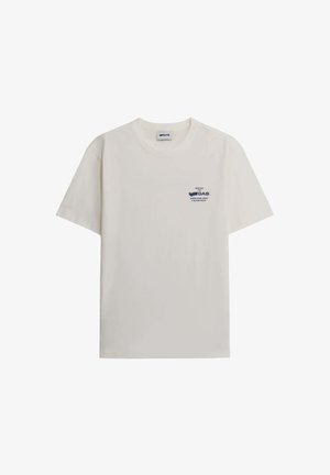 T-shirt in cotone beige chiaro con colletto rotondo, maniche corte e un logo blu stampato nella parte sinistra del petto. Texture liscia, design casual.