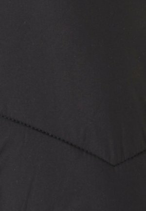 Zwarte stof met een gladde textuur en een chevronpatroon dat is gevormd door contrasterende stiksels. Geen opvallende accenten of metalen onderdelen zichtbaar.