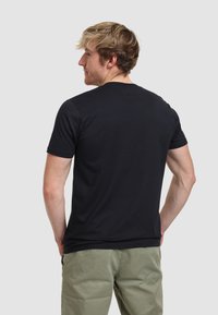 Camiseta negra de manga corta con un diseño ajustado, hecha de una tela suave, con un escote redondo y sin patrones o acentos visibles.