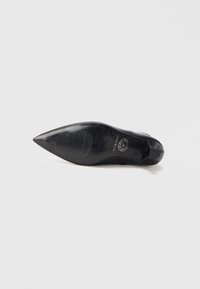 Escarpin noir à bout pointu avec une tige en cuir lisse, une semelle texturée et un talon rond. Présente un logo sur la semelle intérieure.