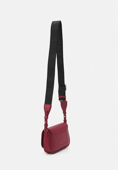 Borsa a tracolla rossa in pelle con finitura testurizzata, dotata di una tracolla nera impresse con "Emporio Armani." I dettagli includono hardware dorato e tracolla regolabile.
