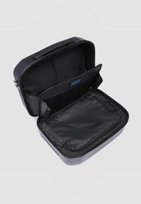 Zwarte harde tas met ritssluiting, voorzien van een ruim interieur en een gaasvak. Soepele textuur en rechthoekige vorm, ideaal voor organisatie.