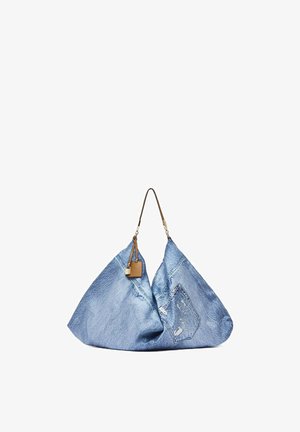 Bolso tote grande de mezclilla azul con una sola correa de cuero marrón y una pequeña etiqueta de cuero adjunta y un candado.