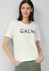 Weißes Baumwoll-T-Shirt mit kurzen Ärmeln, das "CALM" in bunten, gestickten Buchstaben zeigt. Rundhalsausschnitt und lockere Passform.