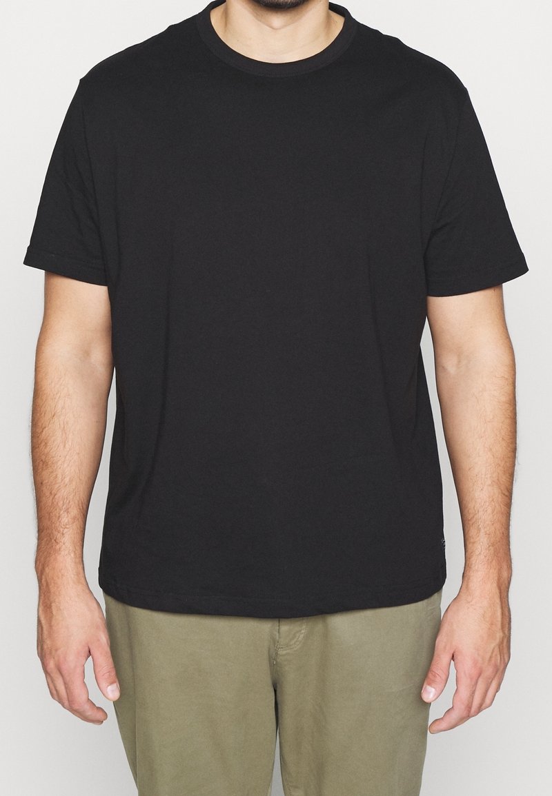 T-shirt noir à manches courtes, col rond, en coton, avec une coupe classique sans logos ni motifs visibles.