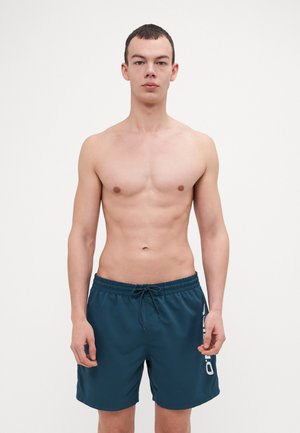 Men's swim shorts in dark teal, made from lightweight material. Features an elastic waistband with a drawstring and side logo detail.