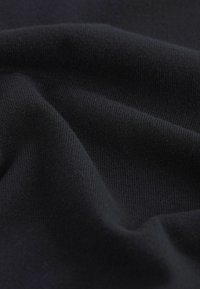 Material textil tricotat de culoare neagră, cu o textură netedă și o ușoară elasticitate, având un model fin cu nervuri și o culoare uniformă pe întreaga suprafață.