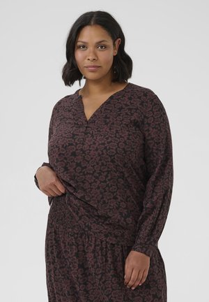 Camicia a maniche lunghe con stampa floreale scura, caratterizzata da scollo a V e orlo arricciato. Realizzata in tessuto morbido con una vestibilità ampia e rilassata.