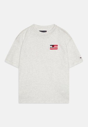 Lysegrå T-shirt med korte ærmer og rund hals med lille rødt, hvidt og blåt Tommy Hilfiger-logo på brystet og ærmet.