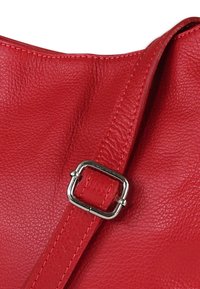 Rode leren handtas met een getextureerd oppervlak, voorzien van een zilveren metalen gesp op de riem en contrasterende stiksels langs de randen.