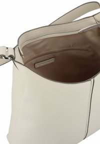 Sac à main en cuir crème avec une surface texturée, une bandoulière unique et un intérieur doublé avec une poche zippée.