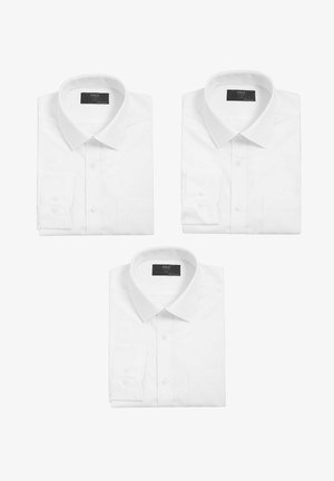 Tre foldede hvide skjorter med lange ærmer, spidse kraver og knaplukning på manchetterne, arrangeret på en ensfarvet hvid baggrund.