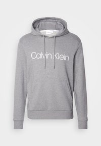 Sweat à capuche gris Calvin Klein avec poche ventrale, capuche à cordon et logo blanc sur la poitrine.