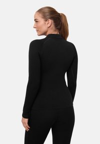 Schwarzes eng anliegendes Langarmshirt mit hohem Kragen, nahtlosem Design und glatter Textur. Verfügt über dezente Nähte entlang der Schultern.