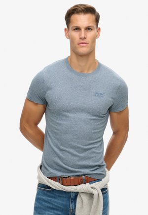 Blå heathered kortærmet t-shirt med rund hals, tætsiddende design og et lille logo på brystet, parret med denim jeans og en lys sweater.