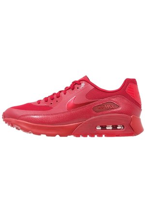 Czerwony but sportowy Nike Air Max z widoczną poduszką powietrzną, teksturowaną skórzaną i siateczkową cholewką oraz czerwonymi sznurowadłami.