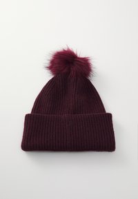 Bonnet en tricot bourgogne avec un revers et un pompon duveteux sur le dessus ; présente une texture côtelée et un aspect doux.