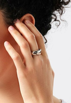 Sterling Silberring mit einem glatten, abgerundeten Design und zwei ineinander greifenden Bändern, das mit einer polierten Oberfläche und subtiler Textur glänzt.