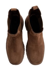 Botas de tobillo de ante marrón con paneles laterales elásticos, punteras redondeadas y suelas texturizadas. Presenta acentos de costura a lo largo de los bordes.