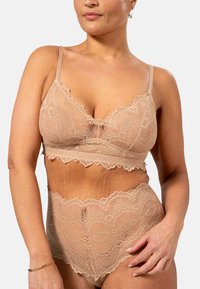 Spetsbralette och högmidjade trosor i nude, med flikiga kanter och intrikata blommönster. Justerbara band, elastisk textur.