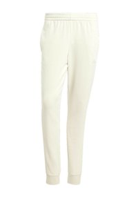 Pantaloni della tuta color crema con elastico in vita e polsini elasticizzati, realizzati in tessuto morbido. Presentano un logo discreto vicino all'anca.