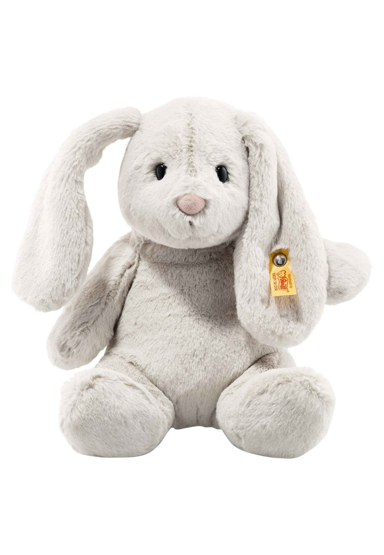 Soft, light gray plush rabbit with long floppy ears, round body, and black eyes. Features a tan tag with a golden bell attached to the ear.