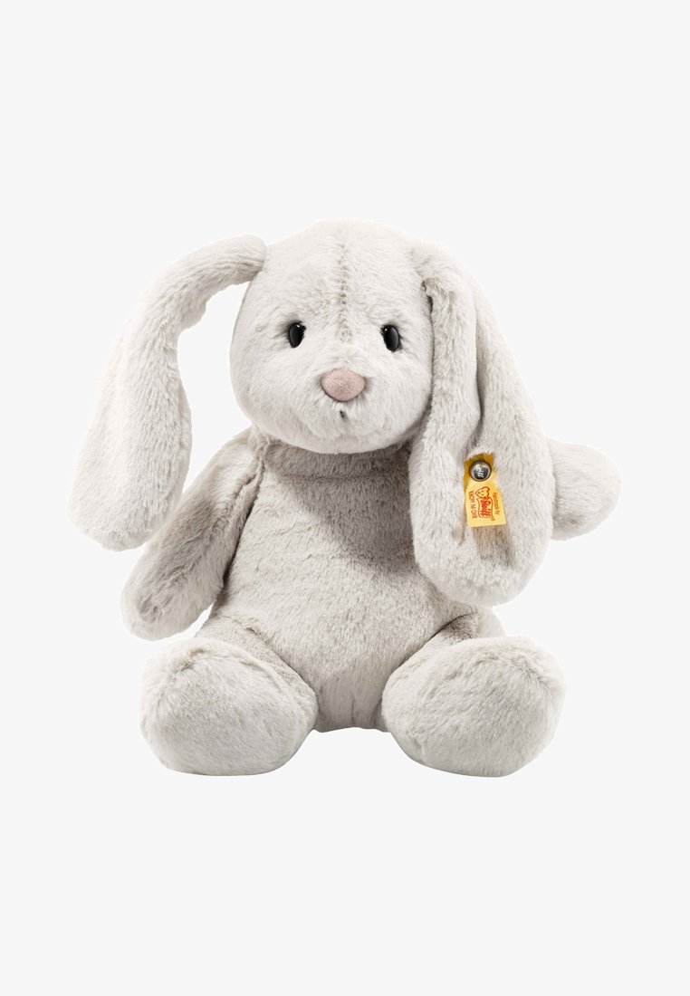 Soft, light gray plush rabbit with long floppy ears, round body, and black eyes. Features a tan tag with a golden bell attached to the ear.