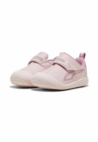 Light pink athletic shoes with a smooth leather upper, elastic straps, mesh accents, and a rounded toe design. Features a textured sole.