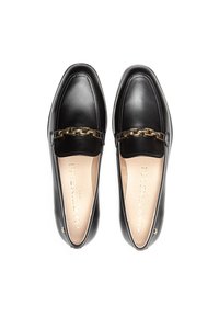 Mocasines de piel negra con un acento de cadena dorada, punta redondeada, textura suave y una plantilla con marca. Diseño clásico y plano.